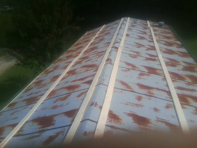 Rusted metal roof panels with new wood purlins before replacement — Storm Damage Roof Repair in Mims by Roofing Brothers