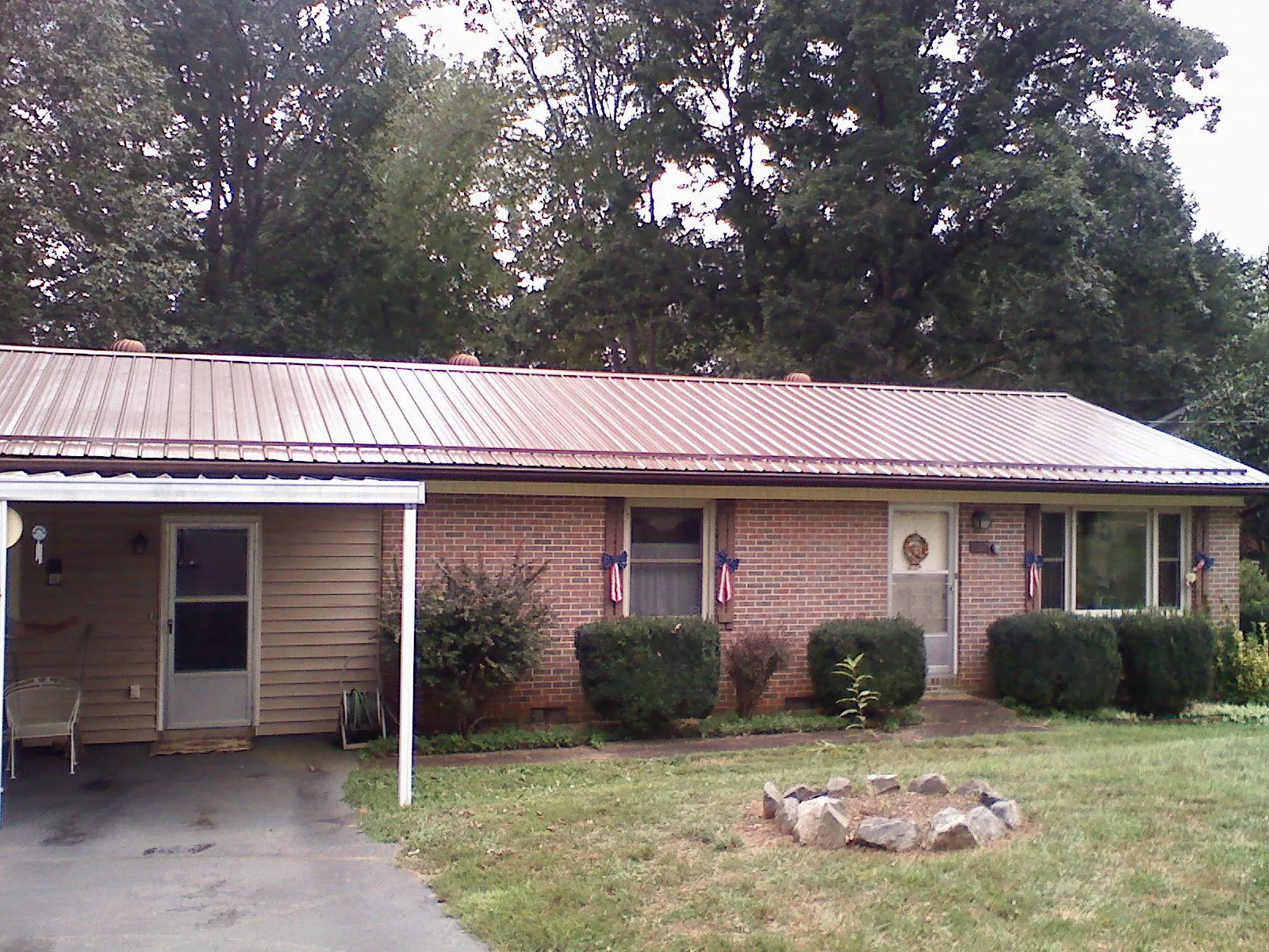Bronze metal roof and carport on a brick ranch home — Roof Repair work by our crew in Mims