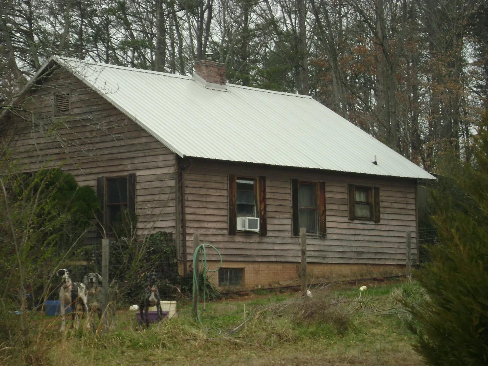 White metal roof on an old wood sided farmhouse, from a Metal Roof Installation job in Mims